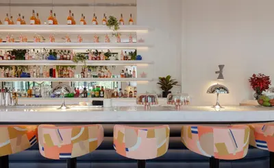 a bar with colorful chairs in front of a counter at MAP Boutique Hotel in Nicosia