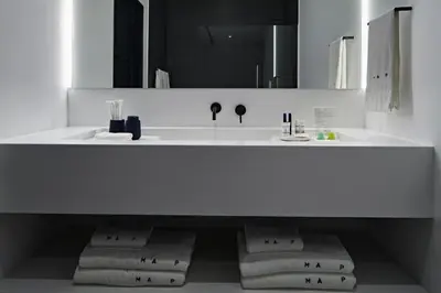 a white bathroom with a sink and a mirror at MAP Boutique Hotel in Nicosia
