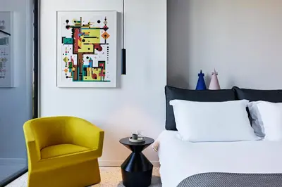 a bedroom with a bed and a yellow chair at MAP Boutique Hotel in Nicosia