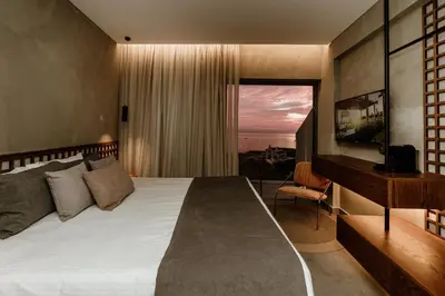 a bedroom with a bed with a desk and a window at Cavo Zoe Seaside Hotel in Protaras