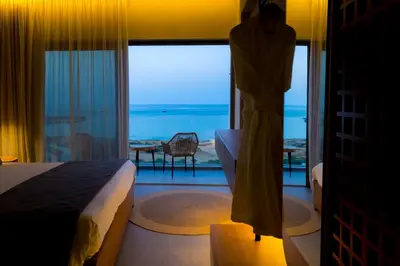 a bedroom with a bed and a view of the ocean at Cavo Zoe Seaside Hotel in Protaras