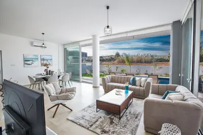 a living room with couches and a tv and a table at Olivine Pearl Villas in Protaras