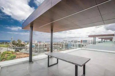 a bench on a balcony with a view of the city at Olivine Pearl Villas in Protaras