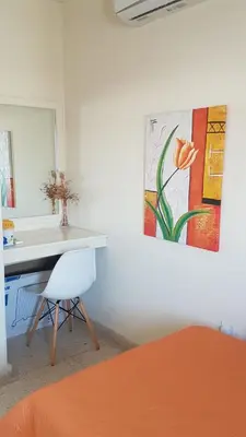 a room with a desk and a painting on the wall at Panorama Beach House, 5 meters to the sea in Pervolia