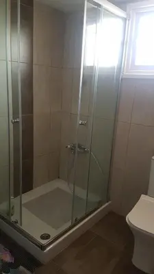 a shower with a glass door in a bathroom at Panorama Beach House, 5 meters to the sea in Pervolia