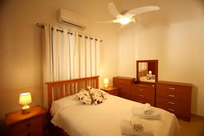 a bedroom with a bed and a ceiling fan at Pissouri Bay Bungalow in Pissouri