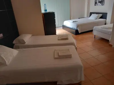 a hotel room with two beds and two tables at Saint John Sia house in Nicosia