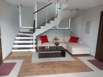 a living room with a couch and a staircase at Saint John Sia house in Nicosia