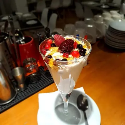 a dessert with fruit in a martini glass on a table at La Veranda Hotel in Larnaka