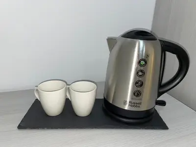 a coffee pot and two cups on a counter at La Veranda Hotel in Larnaka