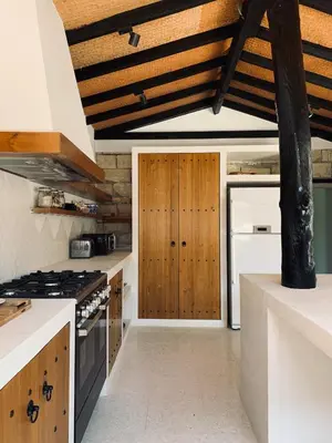 a kitchen with white counters and a wooden ceiling at The Goathouse in Larnaka
