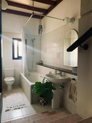 a bathroom with a tub and a sink and a toilet at The Goathouse in Larnaka