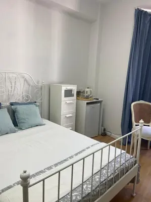 a bedroom with a white bed and a chair at Unique Studios Phaneromenis 41 - Down Town Nicosia in Nicosia