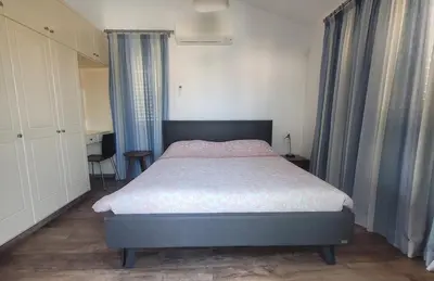 a bedroom with a bed in a room with curtains at Poros 2 Villa in Protaras