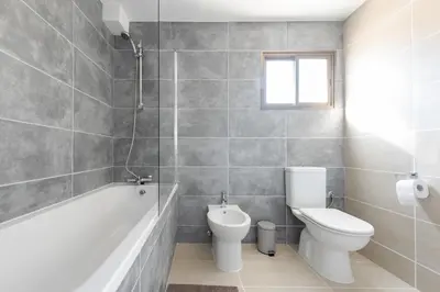 a bathroom with a tub and a toilet and a sink at Sun city apartment in Limassol