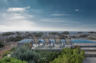 a group of chairs sitting next to a pool at Villa Othelo in Ayia Napa