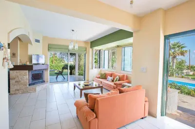 a living room with orange furniture and a fireplace at Villa Joy in Protaras