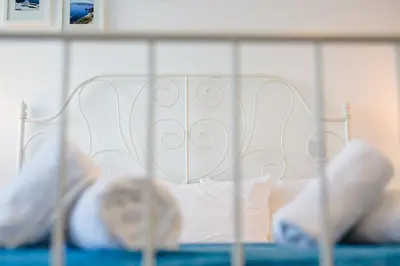 a white bed with white sheets and pillows at Krasas Beach Apts in Larnaka