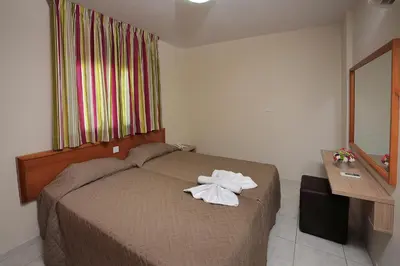 a bedroom with a bed with towels on it at Nelia Gardens in Ayia Napa