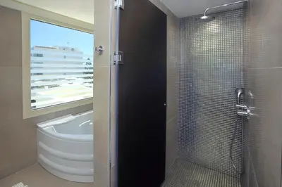 a bathroom with a shower with a toilet and a sink at Nelia Beach Hotel & Spa in Ayia Napa