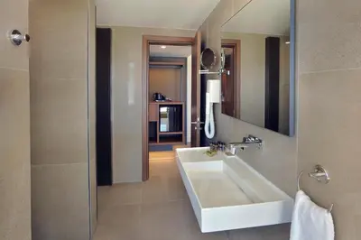 a bathroom with a white sink and a mirror at Nelia Beach Hotel & Spa in Ayia Napa