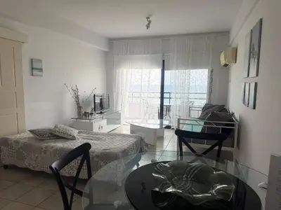 a living room with two beds and a glass table at Krasas Beach Apartments in Larnaka