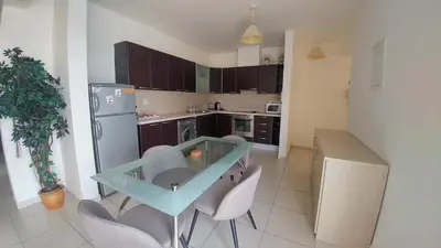 a kitchen with a table and chairs and a refrigerator at Pyla Palms A1 204 in Pyla
