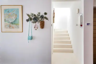 a hallway with stairs and a plant on the wall at Island Home Seaside Villa in Paralimni