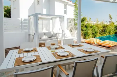 a dining room with a table and chairs and a pool at Island Home Seaside Villa in Paralimni