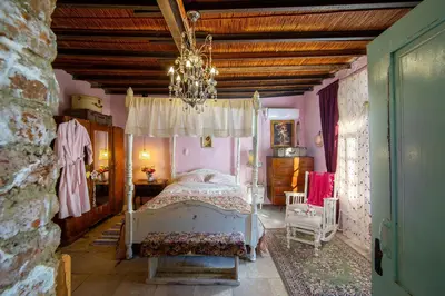 a bedroom with a white bed and a chandelier at Tina's Country Home in Askas