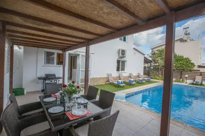 a patio with a table and chairs and a swimming pool at Villa Dionysos in Protaras