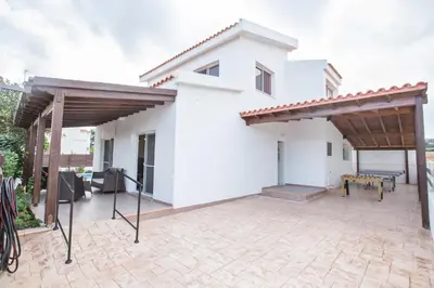 a white house with two pergolas on a patio at Villa Dionysos in Protaras