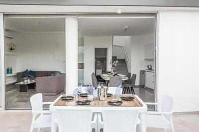a dining room and living room with a table and chairs at Oli Vine Villas in Protaras