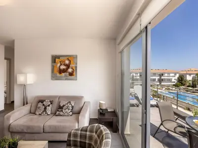 a living room with a couch and a balcony at Mythical Resort by KARMA in Paralimni