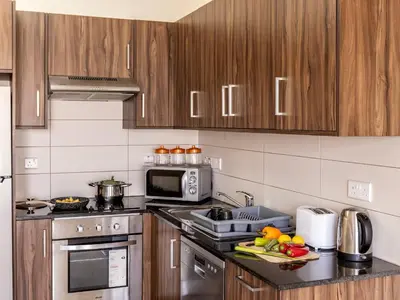 a kitchen with wooden cabinets and a counter top at Mythical Resort by KARMA in Paralimni
