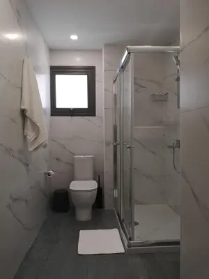 a bathroom with a toilet and a glass shower at Nemesis in Larnaka