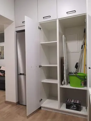 a white closet with shelves and a refrigerator at Nemesis in Larnaka
