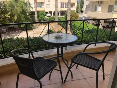 a patio with two chairs and a table on a balcony at Raise Cosy Studio with pool in Limassol in Limassol