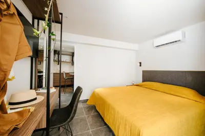 a bedroom with a yellow bed and a chair at Cosmo Napa Boutique Hotel in Ayia Napa