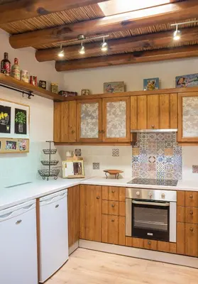 a kitchen with wooden cabinets and white appliances at The Carob Tree Villa - Rustic Luxury Home With Access To Pool And Restaurant in Larnaka