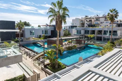 an aerial view of a swimming pool with palm trees and buildings at Carmencita Studio B14 with pool in Limassol