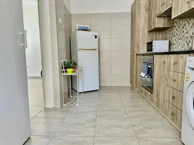 a kitchen with a refrigerator and a table in it at Tsimintia Apt 25 in Larnaka