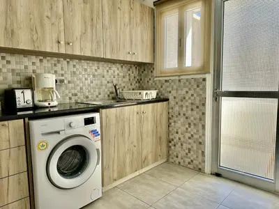 a laundry room with a washing machine in a kitchen at Tsimintia Apt 25 in Larnaka