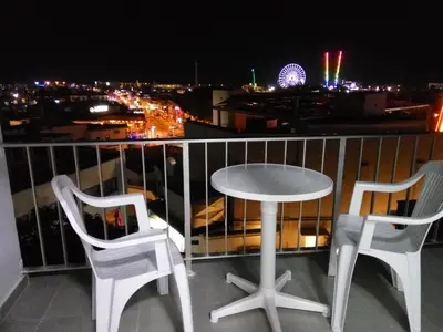 a table and two chairs on a balcony at night at Elenapa Holiday Apartments in Ayia Napa