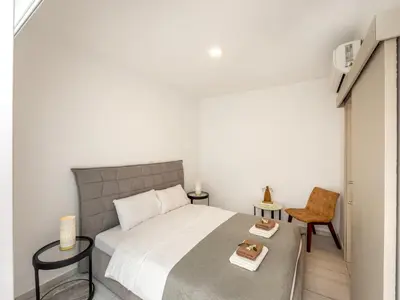 a bedroom with a large bed and a chair at Villa Zoe in Protaras