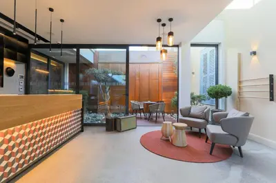 a living room with chairs and a dining room at Hotel Indigo Larnaca by IHG-ADULTS ONLY in Larnaka