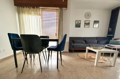 a living room with a table and chairs and a couch at Youthfull Escape in Nicosia in Nicosia