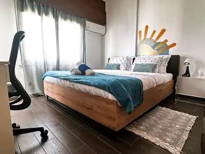 a bedroom with a large wooden bed with blue sheets at Youthfull Escape in Nicosia in Nicosia