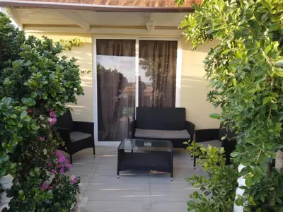 a patio with a couch and a coffee table at MERSINERA Paradise Garden 2 in Larnaka