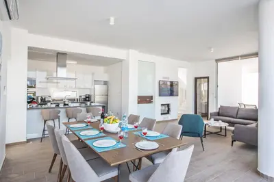 a dining room and living room with a table and chairs at Protaras Olivine Villa OL17 in Protaras